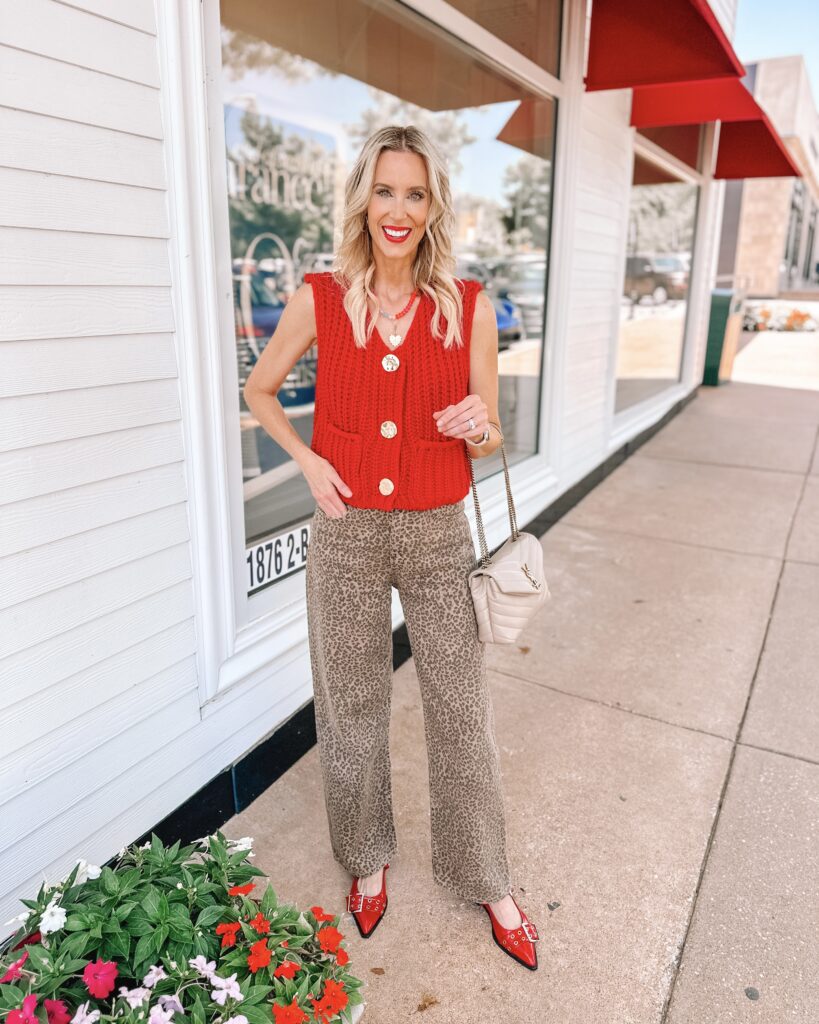 Leopard dresses, pants, tops, shoes, and more are all over. Today I am sharing how to wear leopard jeans including 5 different ways to style them. I love them with this bold red sweater vest and red shoe. 